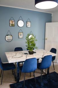 a dining room with a table and blue chairs at The Velveteen Townhouse in Colchester