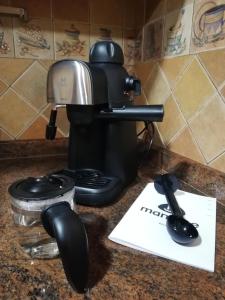 Casa Rural Los Pineros في Montán: آلة صنع القهوة على منضدة بجوار وعاء القهوة