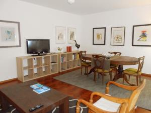 uma sala de estar com uma mesa e uma televisão em Cacao Estoril Apartment em Estoril