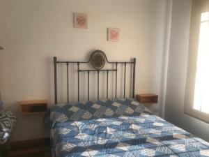 a bedroom with a bed with a blue and white quilt at PAZ EN LA CIUDAD, en el centro, con WIFI y cochera privada in San Antonio de Areco