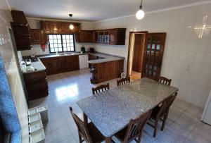 a kitchen with a table with chairs and a counter top at Parada's House in Paredes de Coura