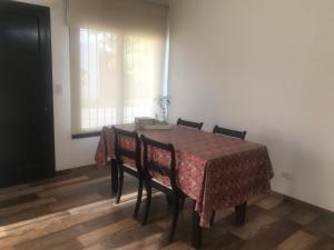 d'une table à manger, de chaises, d'une table et d'une fenêtre. dans l'établissement PAZ EN LA CIUDAD, en el centro, con WIFI y cochera privada, à San Antonio de Areco 6 autres photos
