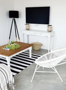 sala de estar con escritorio blanco y silla en Bellas Cottage en Langebaan