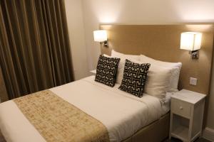 a hotel room with a bed and two lamps at Hyde Park Superior Apartments in London
