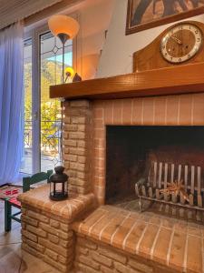 a living room with a brick fireplace with a clock at "Epidavros" Apartment of Levidi Arcadian Apartments in Levidi