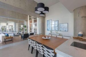 a living room with a wooden table and chairs at Condomínio de Luxo em Frente à Praia (novinho) in Santos