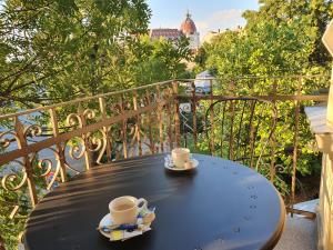 a table with two coffee cups on a balcony at Deák Panzió in Nagykőrös