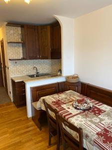 a kitchen with a table with chairs and a sink at Grazioso monolocale a Sestriere in Sestriere