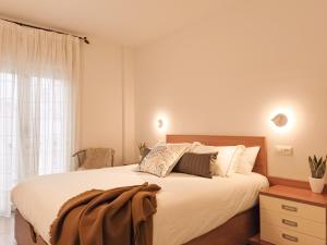 a bedroom with a large white bed and a window at Apartament Natura amb Calma in Olot