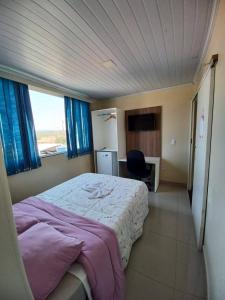 a bedroom with a bed and a chair in it at Hotel Brasília - centro in Brasilia