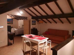 ein Wohnzimmer mit einem Tisch und einem Sofa in der Unterkunft La mansarda del Sacro Bosco in Bomarzo