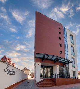 a large red building with stairs in front of it at Signature Aparthotel - Boutique in Galaţi