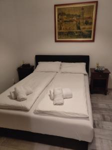 a large white bed with two towels on it at Apartman Zemun Centar in Belgrade
