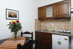 a kitchen with a table with a vase of flowers on it at Afrodite Hotel Apartments in Myrina