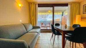 un soggiorno con divano e tavolo di Appartamento Smith Grignolino - Affitti Brevi Italia a Bardonecchia