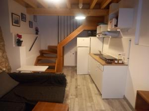pequeña sala de estar con sofá y cocina en El Mullaero, en Aldeanueva del Camino