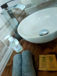 bagno con lavandino, bottiglia d'acqua e asciugamani di Locanda mami ad Aosta