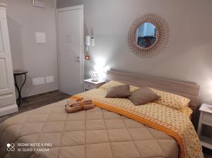 Schlafzimmer mit einem Bett und einem Spiegel an der Wand in der Unterkunft Case Vacanza Le Casette in Santo Stefano di Camastra