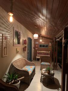 uma sala de estar com cadeiras de vime e um sofá em Sua casa em Angra dos Reis