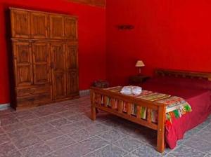 a red bedroom with a wooden bed and a wooden dresser at El Rancho Casa de Campo Exclusiva en Villa de Las Rosas Los impuestos que figuran en la publicación no se cobran in Villa de Las Rosas