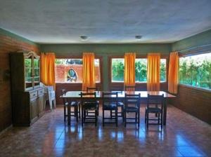 a dining room with a table and chairs and windows at El Rancho Casa de Campo Exclusiva en Villa de Las Rosas Los impuestos que figuran en la publicación no se cobran in Villa de Las Rosas