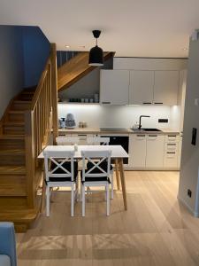 a kitchen with a table and chairs and a staircase at Vanalinna apartment in Haapsalu