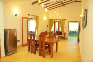 a dining room with a wooden table and chairs at Villa Green Heaven Hikkaduwa in Hikkaduwa