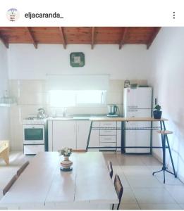 a kitchen with a table and a refrigerator at Eljacaranda_ in Gualeguay +17 photos