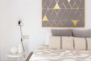 1 dormitorio con 1 cama con una pintura en la pared en Hauzify I Apartamento Ramon y Cajal, en Santa Cruz de Tenerife