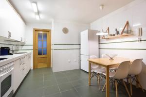cocina con mesa de madera y electrodomésticos blancos en Hauzify I Apartamento Ramon y Cajal, en Santa Cruz de Tenerife