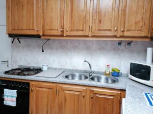 a kitchen with a sink and a stove and cabinets at Casa do Bonifácio in Vilarinho +39 photos