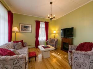 uma sala de estar com dois sofás e uma televisão em Maison des lilas em La Malbaie