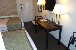 a hotel room with a desk and a bed and a room with a bedskirts at Howard Johnson by Wyndham Las Vegas near the Strip in Las Vegas