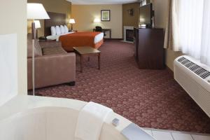 a hotel room with a bed and a bath tub at AmericInn by Wyndham Blue Earth in Blue Earth
