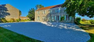 a large driveway in front of a brick house at Logis de Tirac in Lorignac