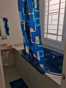 baño con cortina de ducha azul y lavamanos en Encantador - céntrico - apacible departamento en la Roma Norte., en Ciudad de México