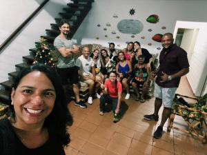 a group of people posing for a picture in front of a christmas tree at Casa da Si Hostel in Ubatuba