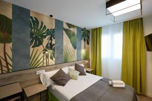 sypialnia z dużym łóżkiem z zielonymi zasłonami w obiekcie Wayteko Boutique Hotel w Alicante