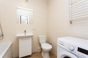 a white bathroom with a toilet and a sink at Бам. Однокімнатна квартира в новобудові in Ternopilʼ +16 photos