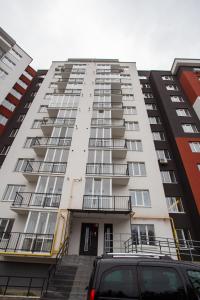 a tall white building with stairs in front of it at Бам. Однокімнатна квартира в новобудові in Ternopilʼ