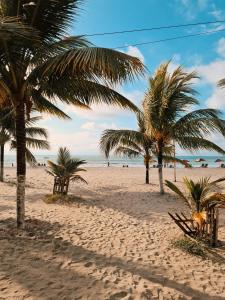 una playa de arena con palmeras y el océano en Hotel Club del Sol, en Atacames