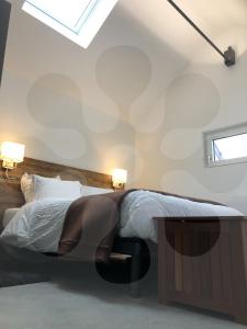 ein Schlafzimmer mit einem Bett und zwei Lampen an der Wand in der Unterkunft L'atelier 1410 in Saint-Amand-les-Eaux
