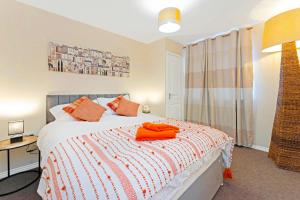 a bedroom with a bed with orange towels on it at Modern & Spacious 2 Bedroom Serviced Apartment Next to Lochend Park - Private Underground Parking & Lift Available - Close to Edinburgh City Centre in Edinburgh