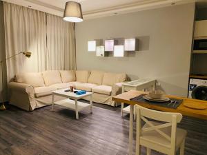 a living room with a couch and a table at Elite Corner Apartment in Ţāb Kirā‘