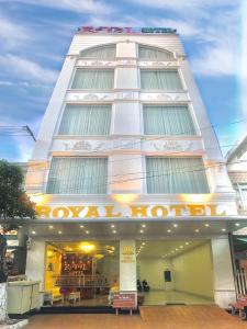 um edifício branco alto com um cartaz em Royal Hotel em Bạc Liêu