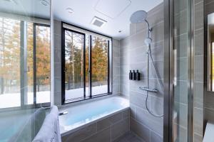 a bathroom with a tub and a window at ROKA by HHG in Hakuba +34 photos