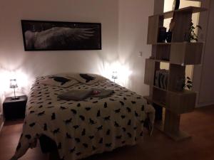 a bedroom with a bed with a black and white comforter at Lovely Appart near Paris, 15 mins to Opéra, Galerie Lafayette, Louvre in Levallois-Perret