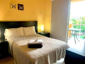 1 dormitorio con 1 cama grande y balcón en Andressa Mia Apartments, en Manzanillo