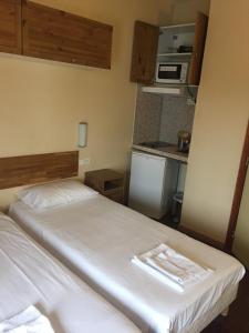 um pequeno quarto com uma cama e uma cozinha em Résidence Molière Hôtel Paris Montrouge em Montrouge