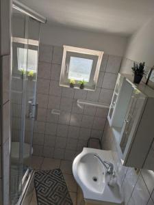 uma casa de banho com um lavatório e um chuveiro em Apartments Biserka - 50 m from beach em Trogir